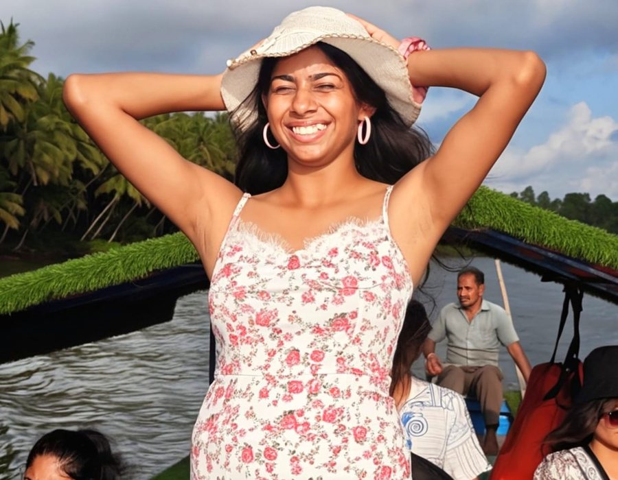 Ami on a backwater boat ride, laughing under a sun hat